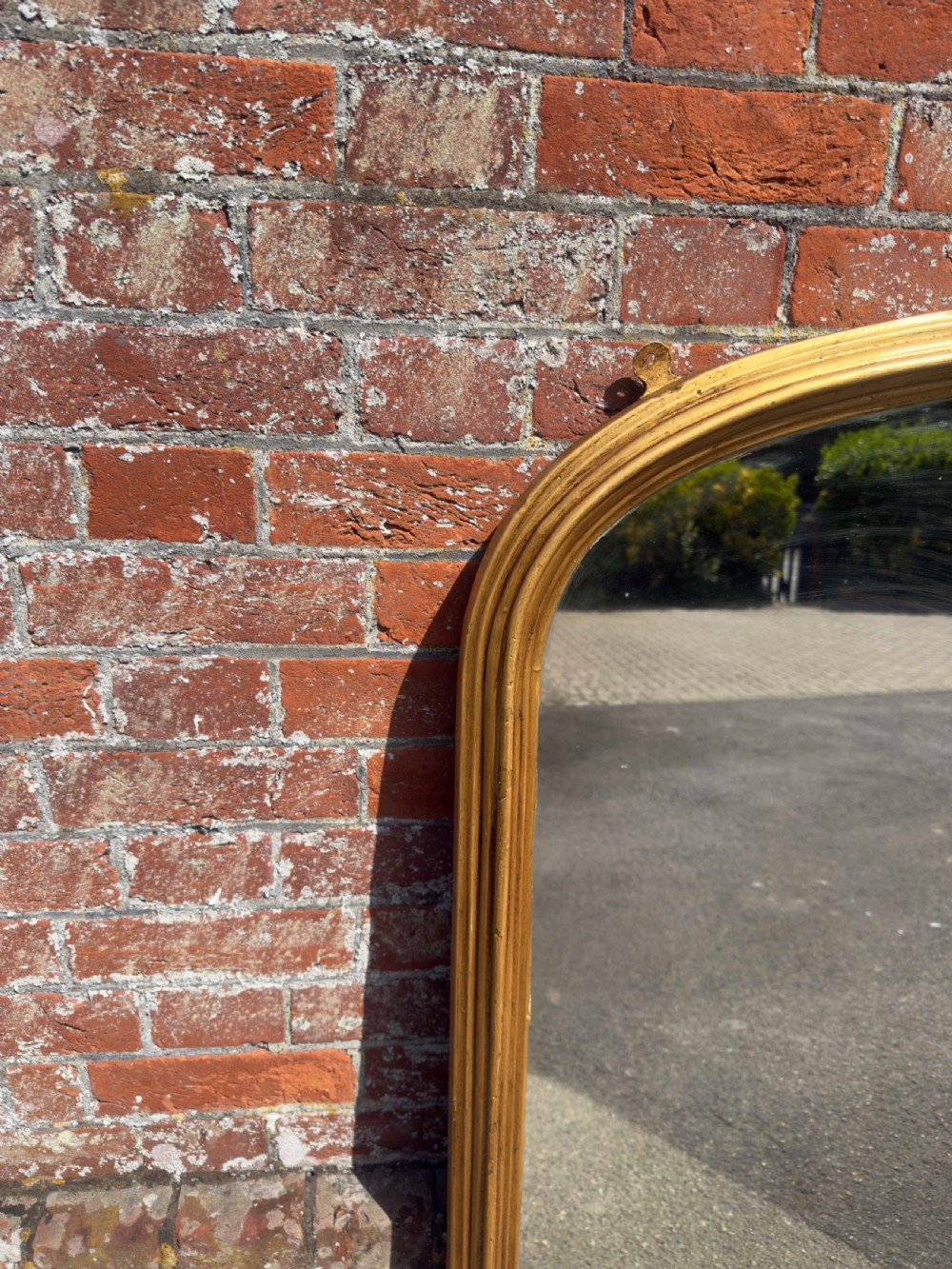 A 19th-century arched overmantel mirror featuring a gilded carved wood frame with integrated side support feet. View III