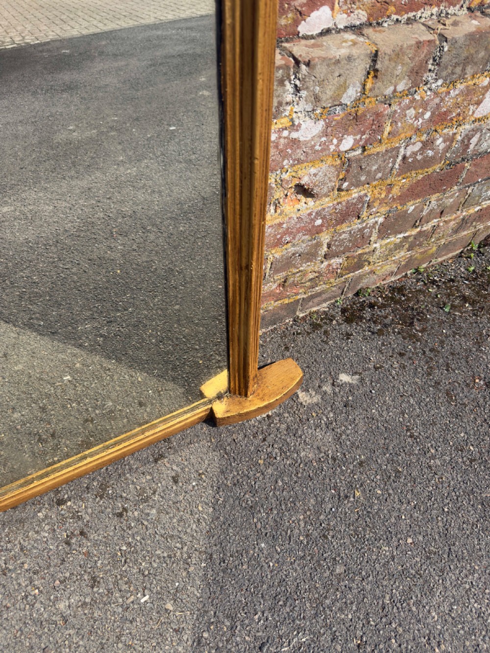 A 19th-century arched overmantel mirror featuring a gilded carved wood frame with integrated side support feet. View V