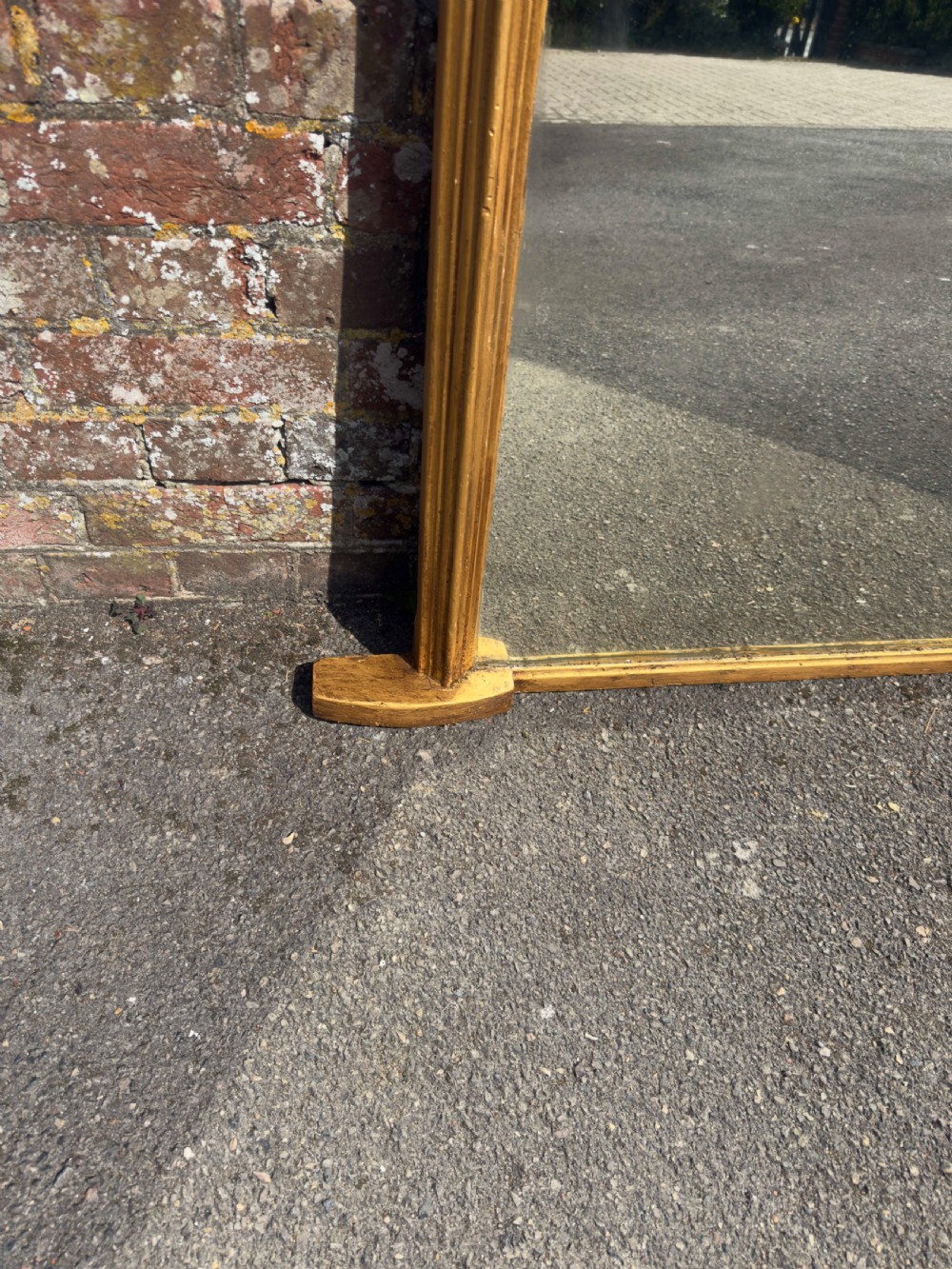 A 19th-century arched overmantel mirror featuring a gilded carved wood frame with integrated side support feet. View VII