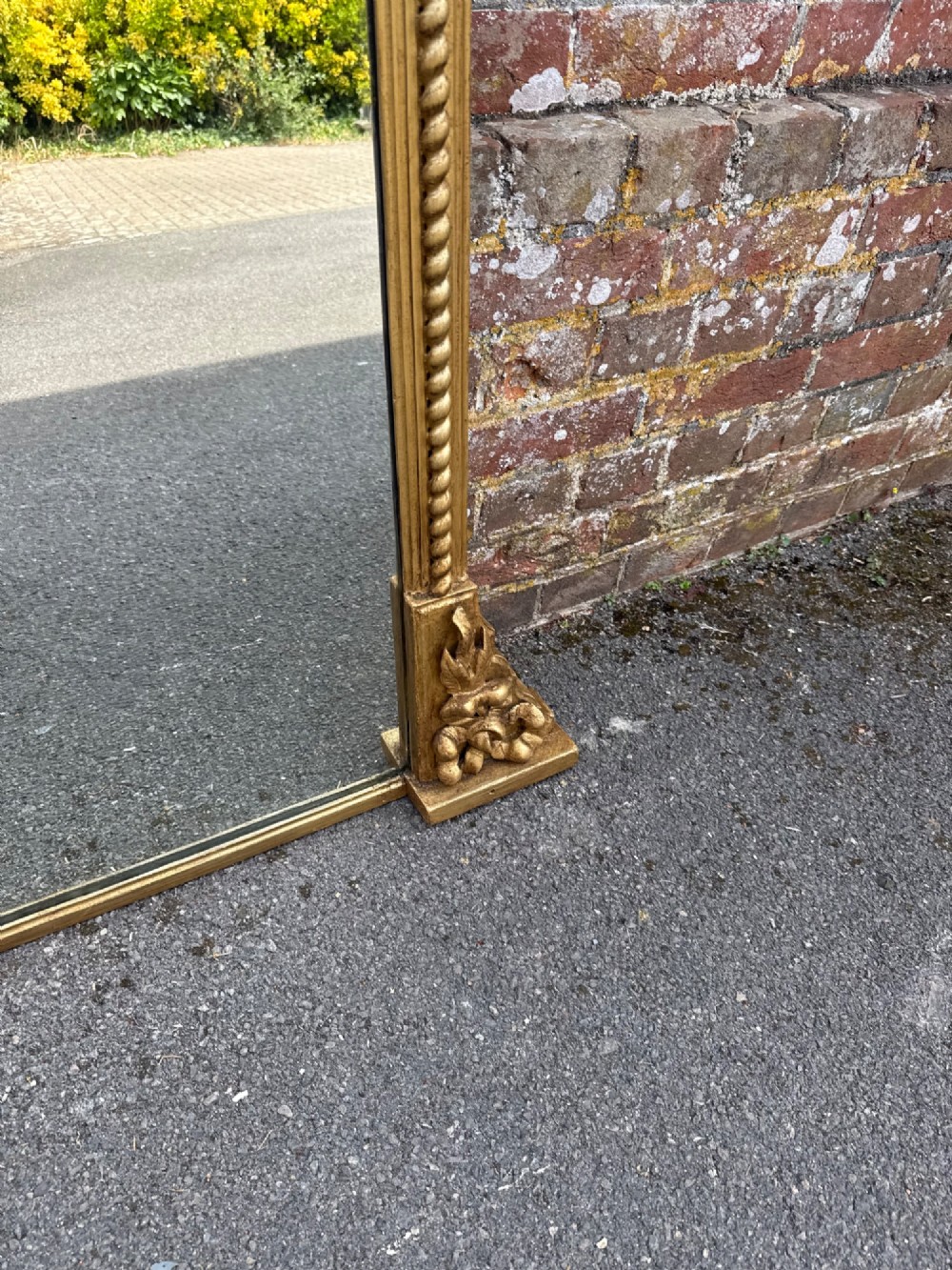 A large 19th-century overmantel mirror featuring a gilded wood frame with a central floral crest, rope-twist side columns, and an arched top. View VI