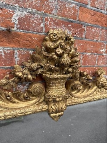 A large nineteenth-century carved giltwood overmantel mirror featuring a prominent central urn crest and floral mouldings. View III