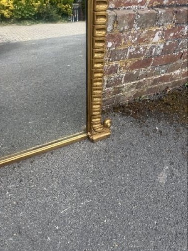 A large 19th-century overmantel mirror featuring an arched gold giltwood frame with fluted moulding detailing and a flat base. View IV