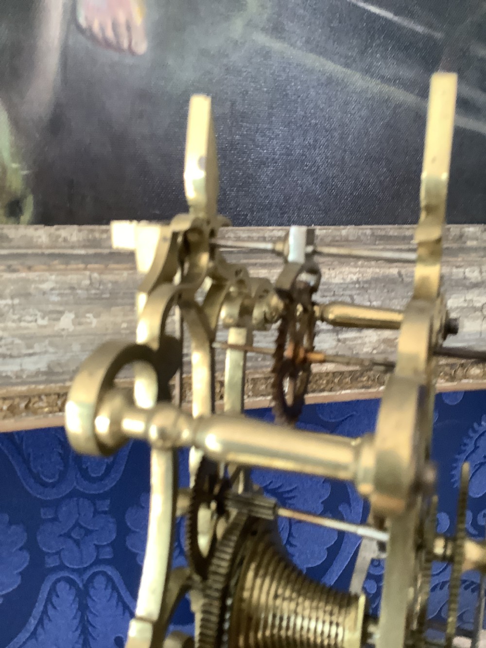 A Victorian brass skeleton clock featuring an openwork frame, pierced chapter ring with Roman numerals, and a white marble plinth base. View VI