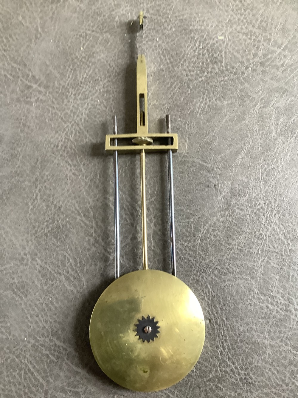 A Victorian brass skeleton clock featuring an openwork frame, pierced chapter ring with Roman numerals, and a white marble plinth base. View XVI