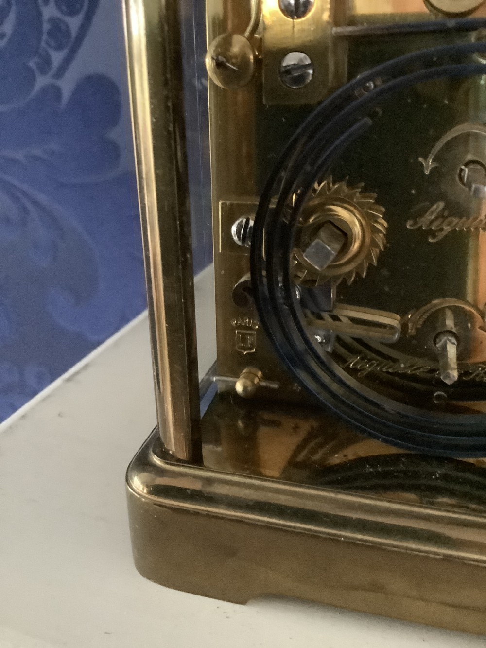 An antique French brass carriage clock featuring a white enamel dial with Roman numerals, a subsidiary dial, and an overhead carrying handle. View II