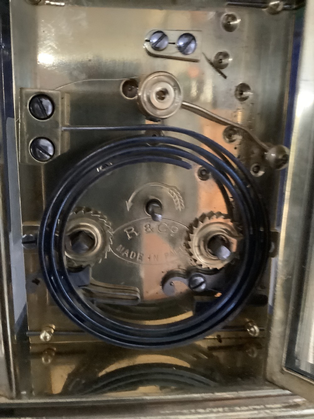An antique French brass carriage clock featuring a white enamel dial with Roman numerals, a subsidiary dial, and an overhead carrying handle. View III