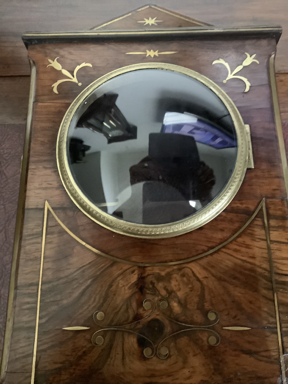 A Regency period wooden table clock with brass inlay, a pediment top, brass lion-head side handles, and a white dial displaying Roman numerals. View III