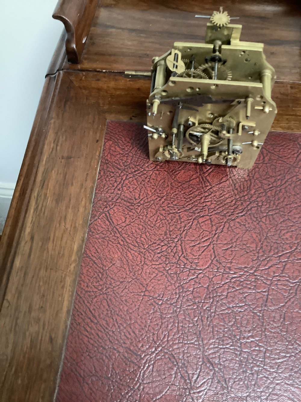 A Regency period wooden table clock with brass inlay, a pediment top, brass lion-head side handles, and a white dial displaying Roman numerals. View XIII