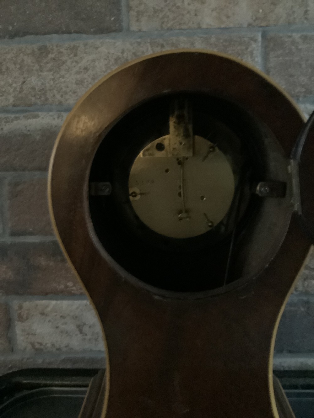 An antique French balloon-shaped wooden mantel clock featuring mahogany veneer with satinwood starburst marquetry inlay, a white dial with Roman numerals, and brass bracket feet. View IV