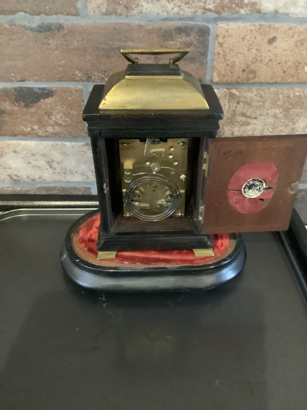 A nineteenth-century French striking mantel clock set within a dark wood and brass-trimmed case with a white enamel dial displaying Roman numerals. View III