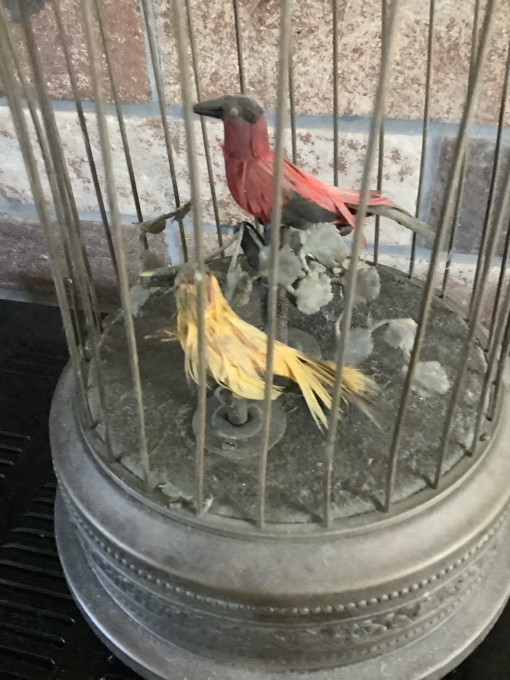 An antique brass domed birdcage automaton featuring two artificial feathered birds perched inside on an ornate base. View III