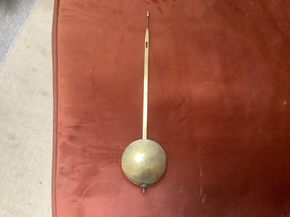 A Victorian carved mahogany fusee wall clock featuring an off-white circular dial with Roman numerals, brass bezel, and ornate matching wooden bracket support. View VII