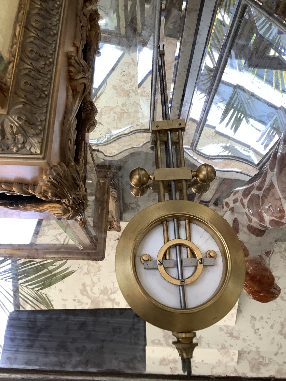 A 19th-century French four-glass mantel clock featuring a gilt brass case with decorative moulding, bevelled glass panels, a white enamel dial with Roman numerals, and a visible mercury pendulum. View VIII