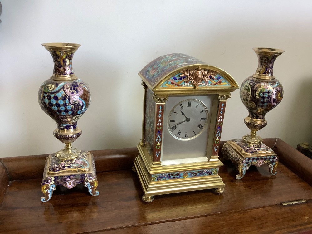 A three-piece French champleve enamel clock garniture set featuring an arched central clock flanked by two matching ornamental vases on gilt bases. View XIII
