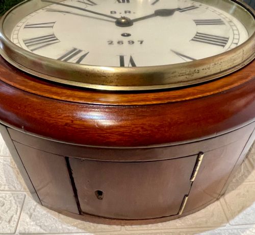 fig 2. A circular antique mahogany fusee wall clock featuring a cream dial marked B.R., Roman numerals, black hands, and a brass bezel.