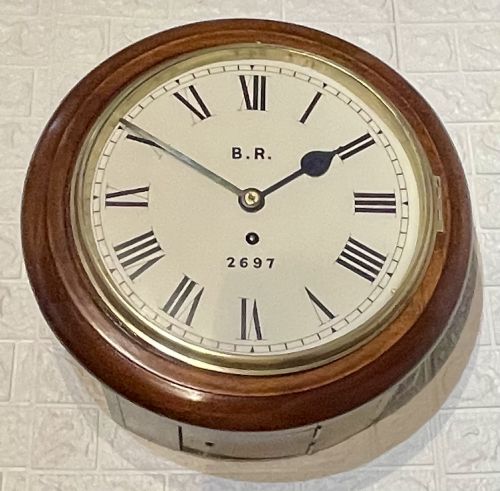 fig 3. A circular antique mahogany fusee wall clock featuring a cream dial marked B.R., Roman numerals, black hands, and a brass bezel.