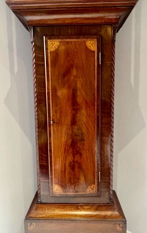fig 5. An antique Scottish Georgian mahogany longcase clock featuring a hand-painted dial, spiral turned columns, and marquetry inlay.