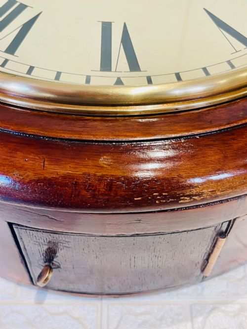 fig 2. A circular Victorian railway dial clock with a dark mahogany frame, brass bezel, and off-white dial featuring black Roman numerals.