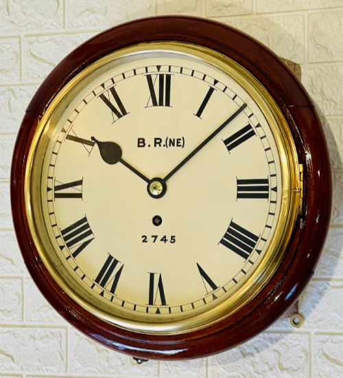 fig 1. A circular 10-inch railway dial wall clock featuring a turned mahogany wooden surround, a brass bezel, and a cream dial marked B.R.(NE) with black Roman numerals.