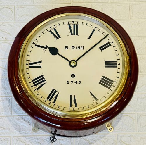 fig 2. A circular 10-inch railway dial wall clock featuring a turned mahogany wooden surround, a brass bezel, and a cream dial marked B.R.(NE) with black Roman numerals.
