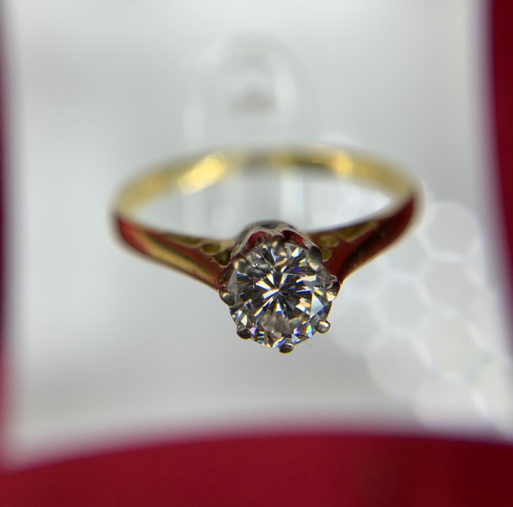 A single round diamond set in platinum claws on an 18ct yellow gold band. View III