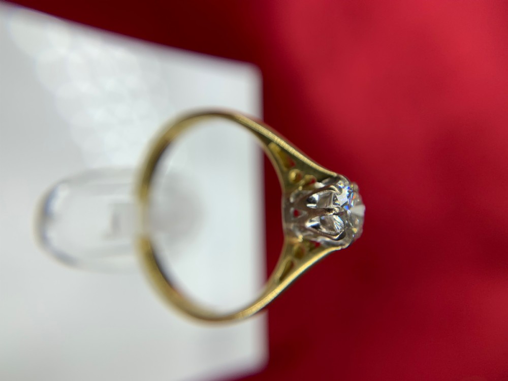 A single round diamond set in platinum claws on an 18ct yellow gold band. View VI