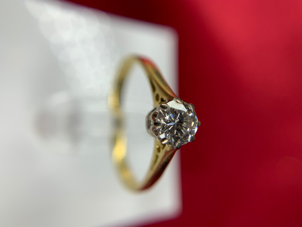 A single round diamond set in platinum claws on an 18ct yellow gold band. View VII