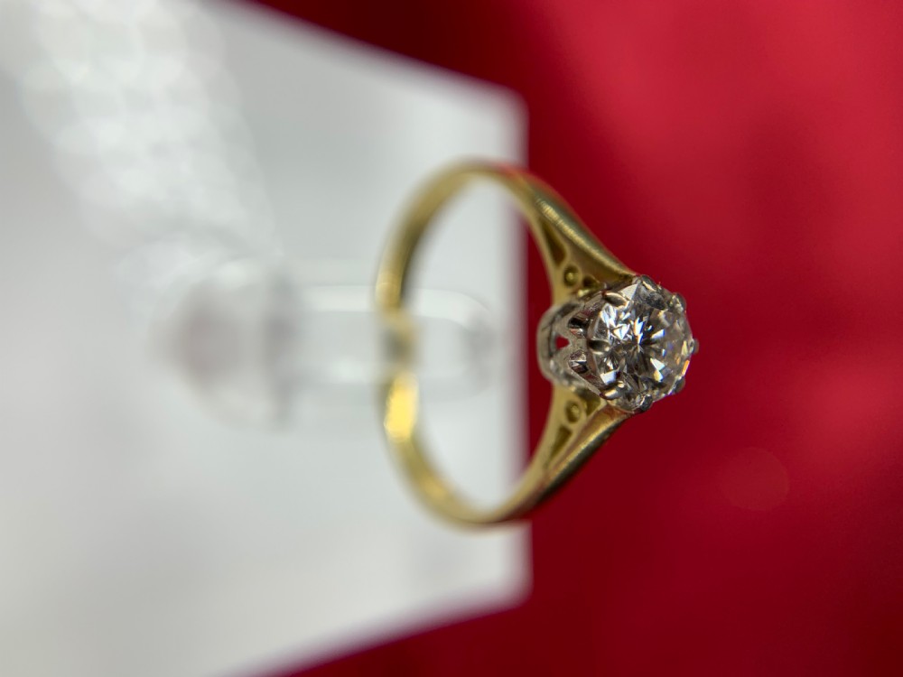 A single round diamond set in platinum claws on an 18ct yellow gold band. View VIII