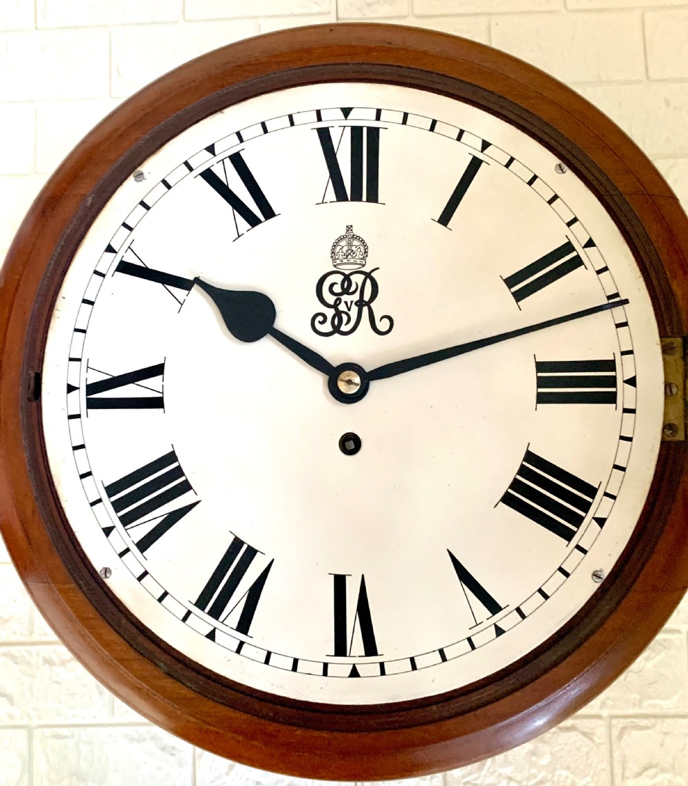 A circular antique fusee wall clock featuring a warm mahogany wooden surround, a brass glass bezel, and a white painted dial with black Roman numerals and a GVR royal cypher monogram. View III