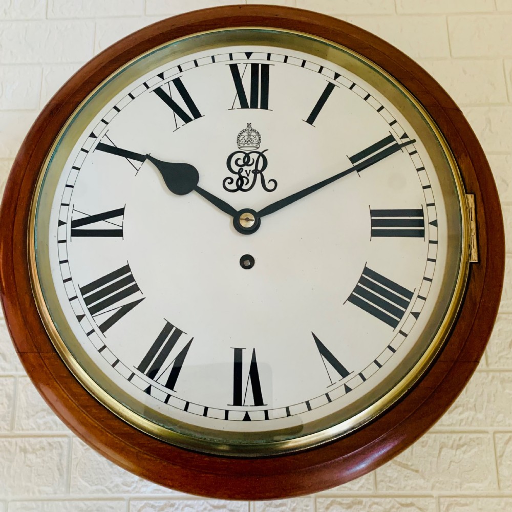 A circular antique fusee wall clock featuring a warm mahogany wooden surround, a brass glass bezel, and a white painted dial with black Roman numerals and a GVR royal cypher monogram. View VI