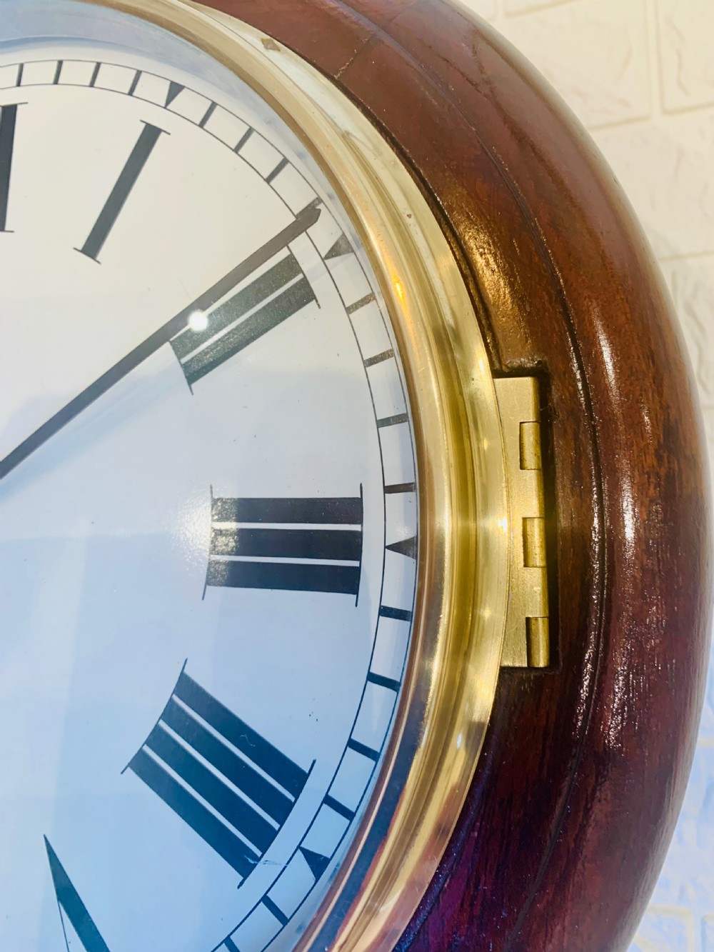 A circular dark wood wall clock featuring a white dial with black Roman numerals, brass bezel, and GPO EIIR markings. View X