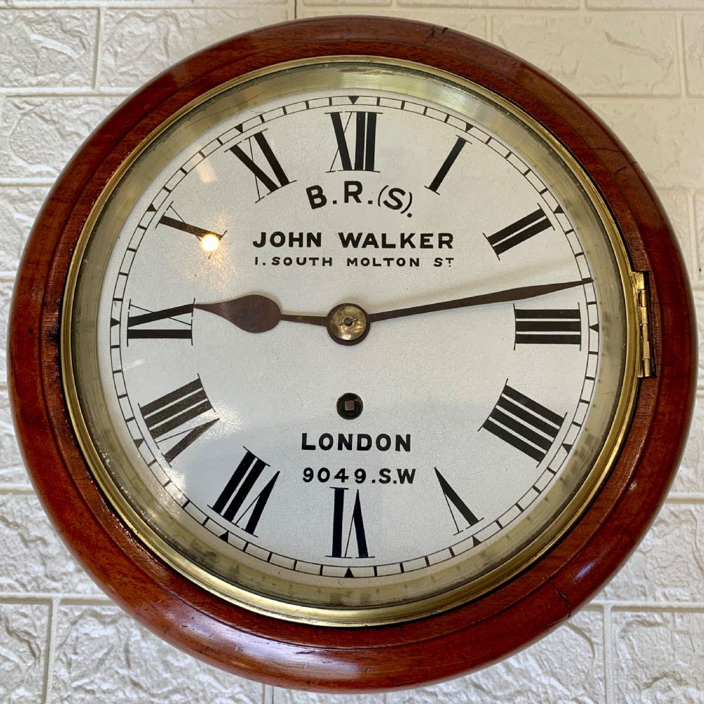 An antique circular mahogany wall clock featuring a cream dial with black Roman numerals and British Railways lettering, framed by a brass bezel.