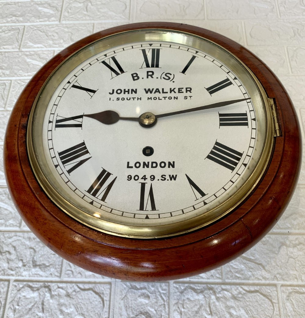 An antique circular mahogany wall clock featuring a cream dial with black Roman numerals and British Railways lettering, framed by a brass bezel. View II