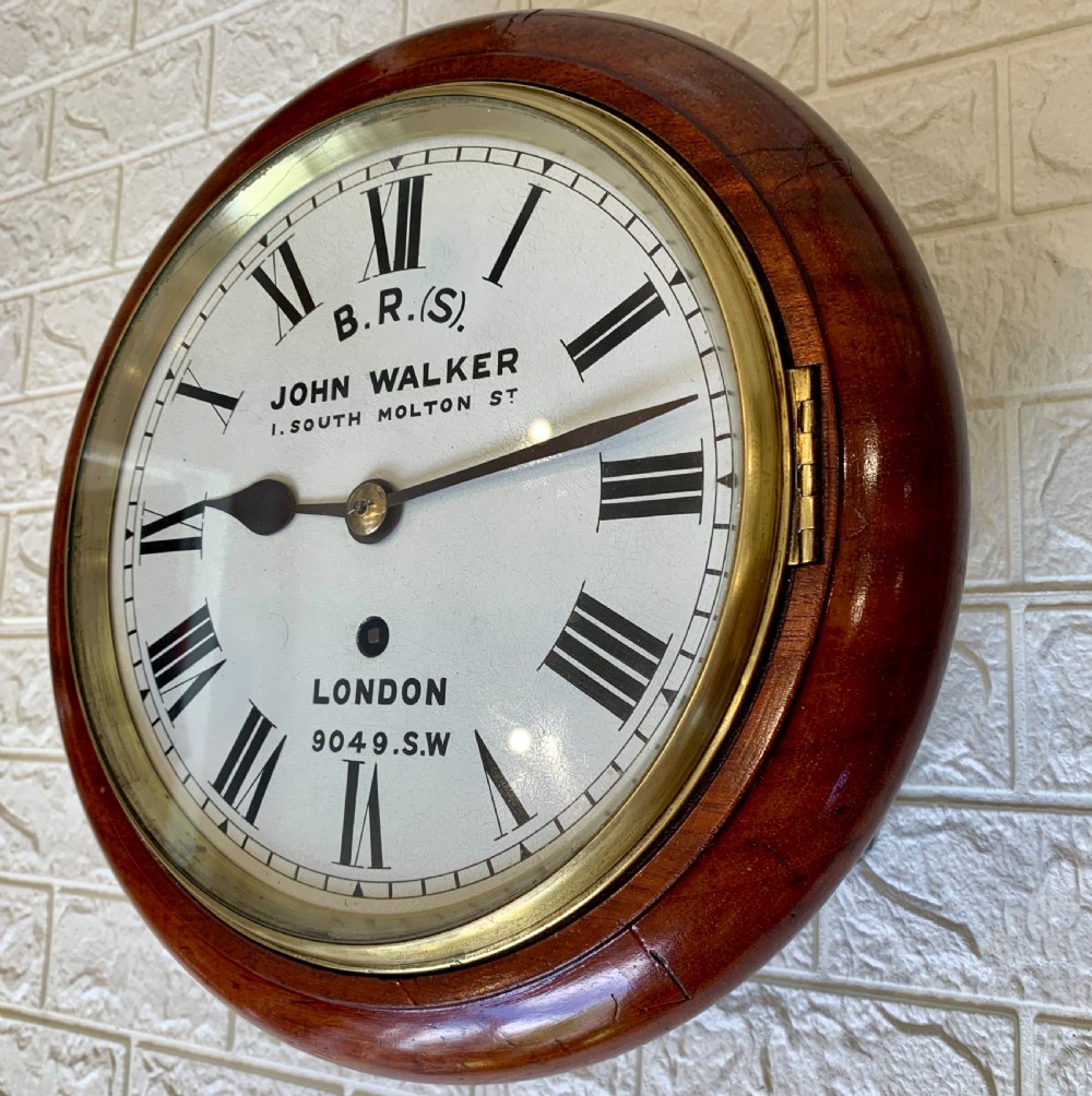 An antique circular mahogany wall clock featuring a cream dial with black Roman numerals and British Railways lettering, framed by a brass bezel. View III