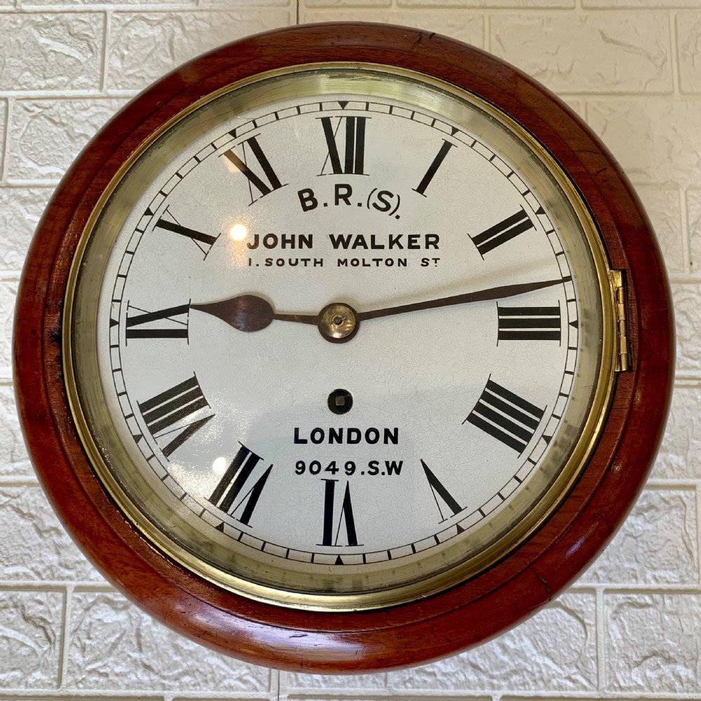 An antique circular mahogany wall clock featuring a cream dial with black Roman numerals and British Railways lettering, framed by a brass bezel. View IV