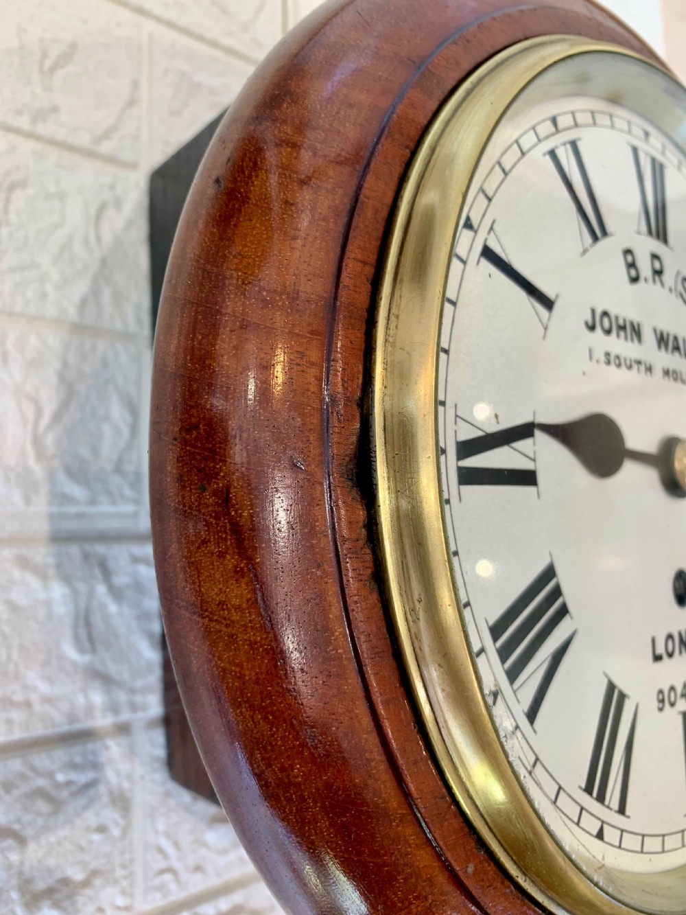 An antique circular mahogany wall clock featuring a cream dial with black Roman numerals and British Railways lettering, framed by a brass bezel. View V