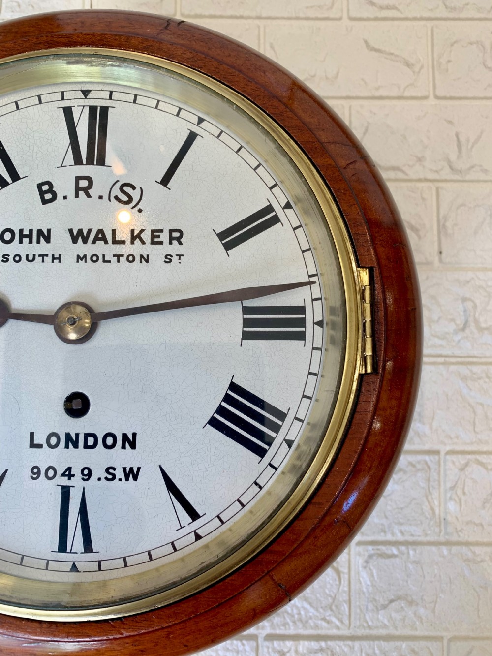An antique circular mahogany wall clock featuring a cream dial with black Roman numerals and British Railways lettering, framed by a brass bezel. View VII