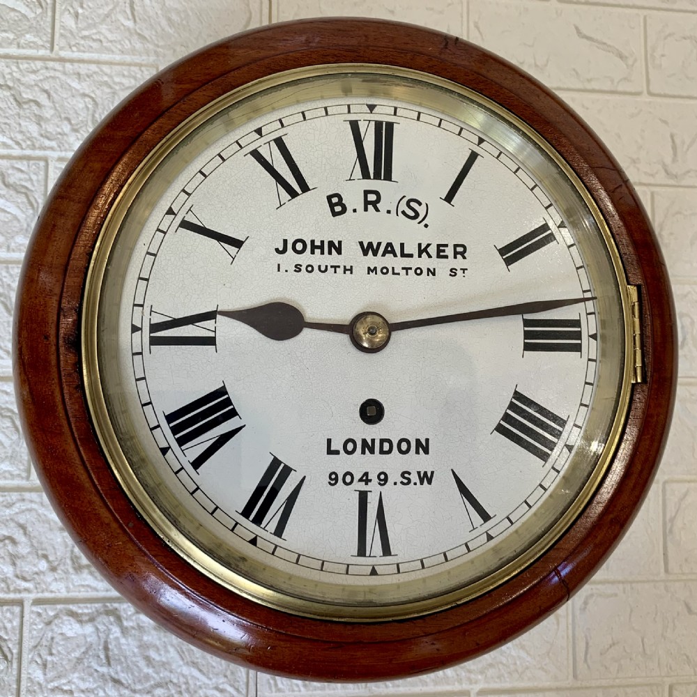 An antique circular mahogany wall clock featuring a cream dial with black Roman numerals and British Railways lettering, framed by a brass bezel. View VIII