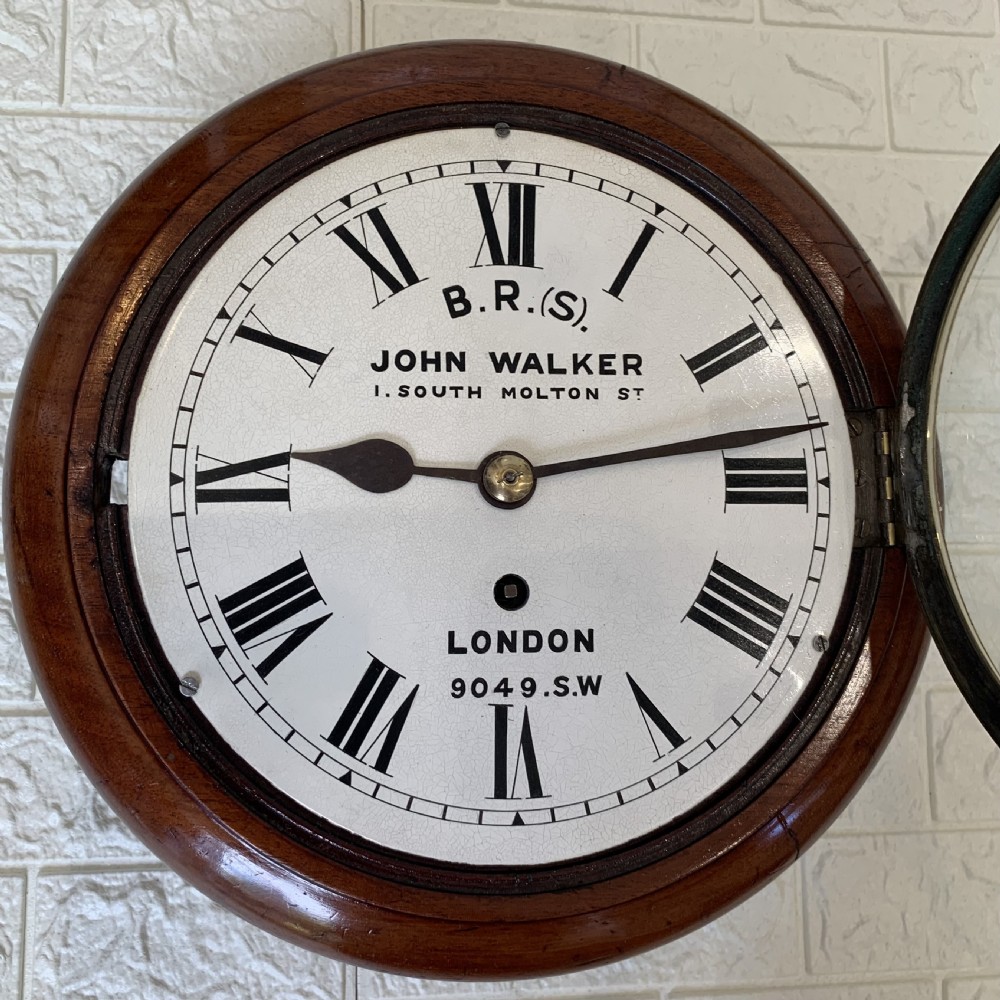 An antique circular mahogany wall clock featuring a cream dial with black Roman numerals and British Railways lettering, framed by a brass bezel. View IX