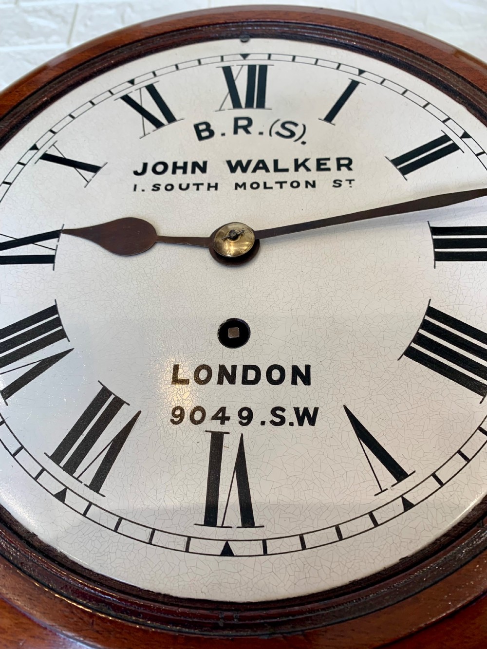 An antique circular mahogany wall clock featuring a cream dial with black Roman numerals and British Railways lettering, framed by a brass bezel. View X