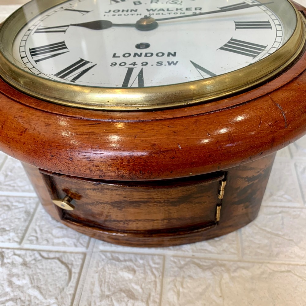 An antique circular mahogany wall clock featuring a cream dial with black Roman numerals and British Railways lettering, framed by a brass bezel. View XVI