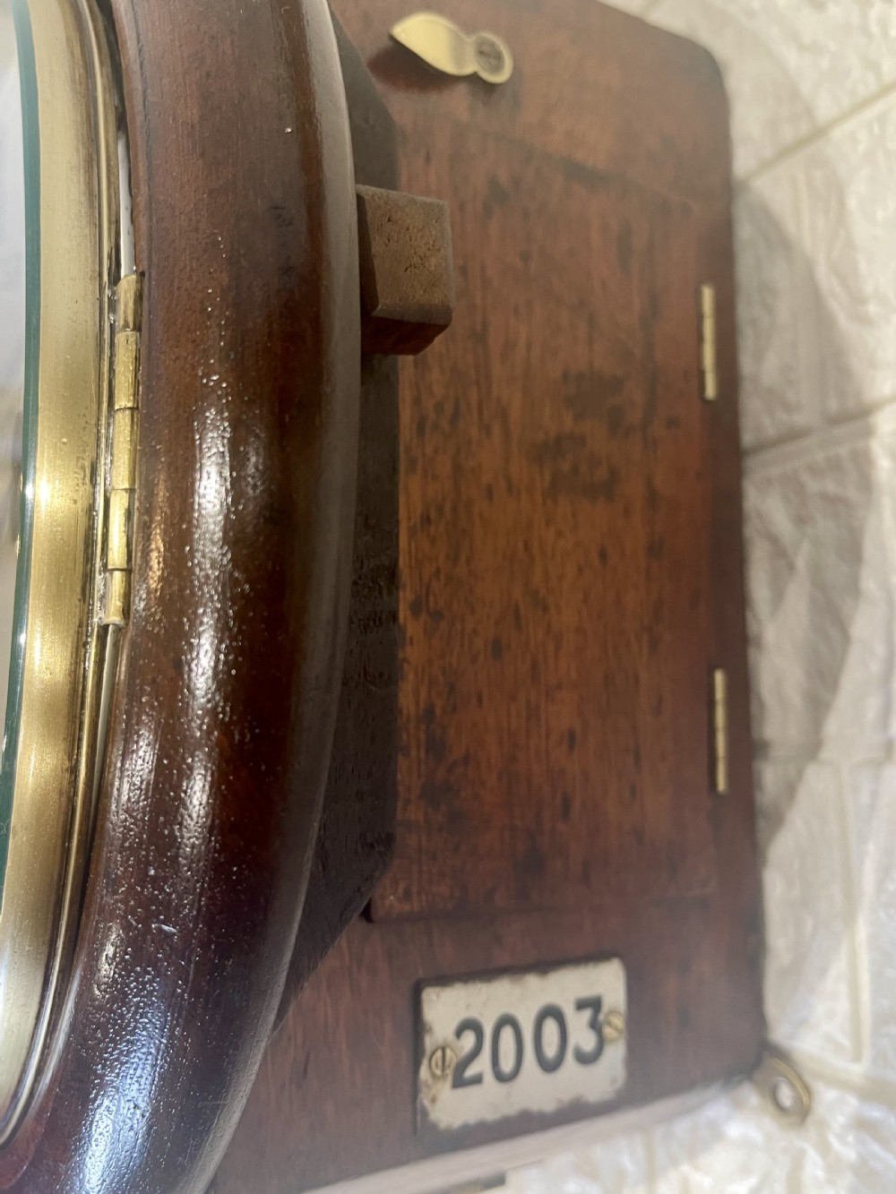 An antique circular mahogany wall clock with a brass-hinged glass bezel, white dial featuring Roman numerals, and black markings reading LMSR John Walker London. View XIII