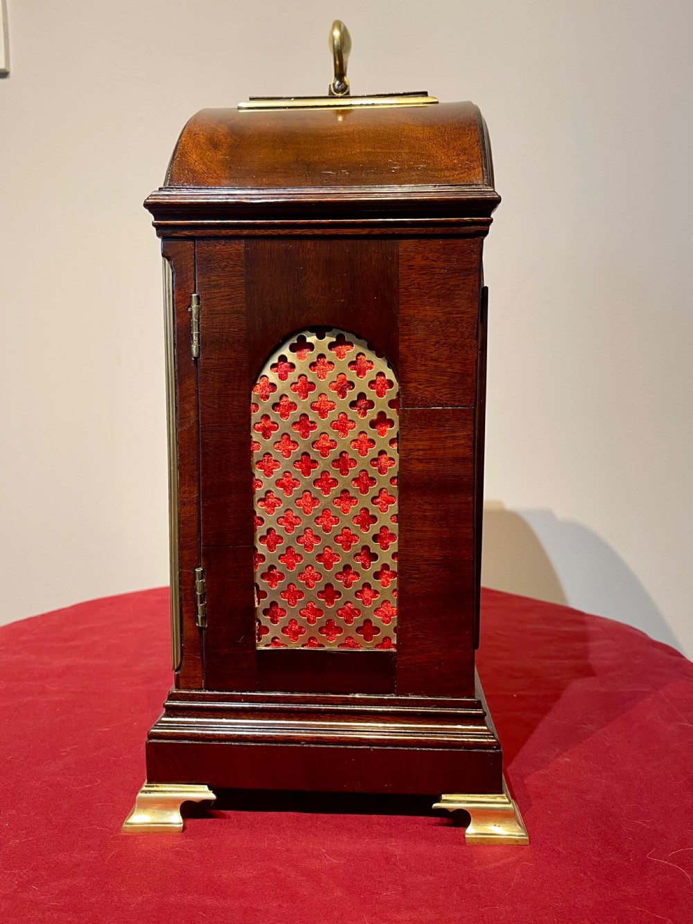 A George III mahogany bracket clock featuring an arched top with a brass handle, a circular white dial with Roman numerals, and brass bracket feet. View XIII