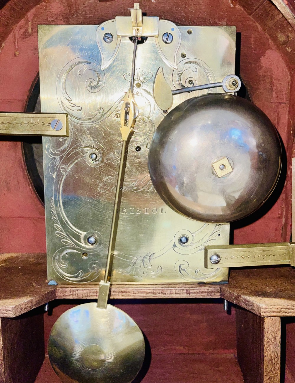 A George III mahogany bracket clock featuring an arched top with a brass handle, a circular white dial with Roman numerals, and brass bracket feet. View XV