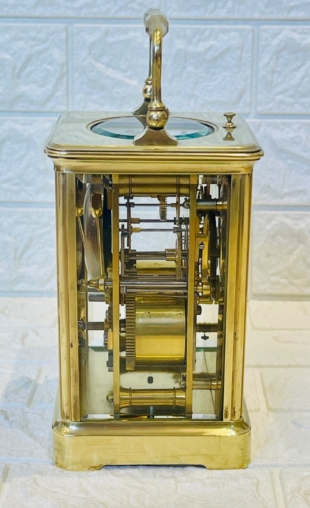 An antique brass carriage clock featuring a rectangular glass case, top carrying handle, and a white enamel dial with black Roman numerals. View XIII