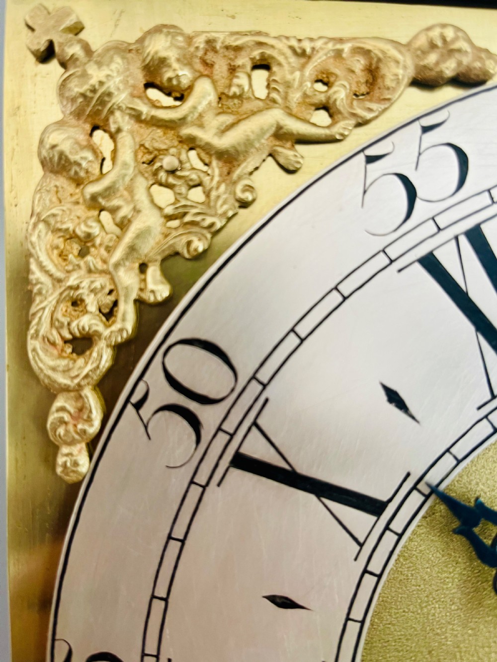 An 18th-century Georgian oak longcase clock featuring a square brass dial with silvered chapter ring, brass spandrels, twin brass finials, and a tall slender timber case. View XVIII