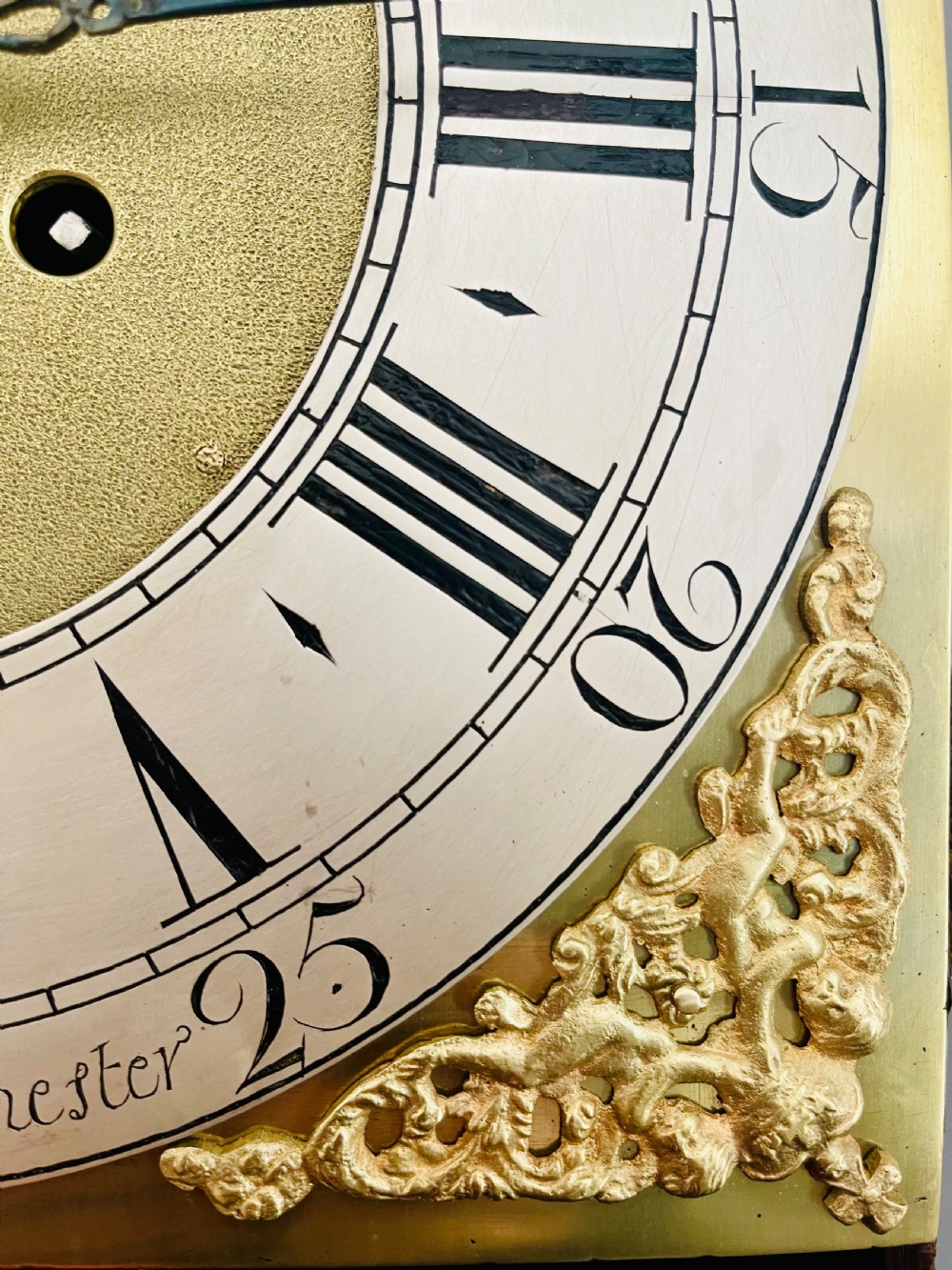 An 18th-century Georgian oak longcase clock featuring a square brass dial with silvered chapter ring, brass spandrels, twin brass finials, and a tall slender timber case. View XIX