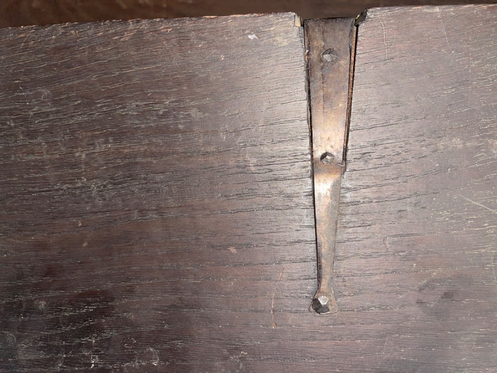 An 18th-century Georgian oak longcase clock featuring a square brass dial with silvered chapter ring, brass spandrels, twin brass finials, and a tall slender timber case. View XX