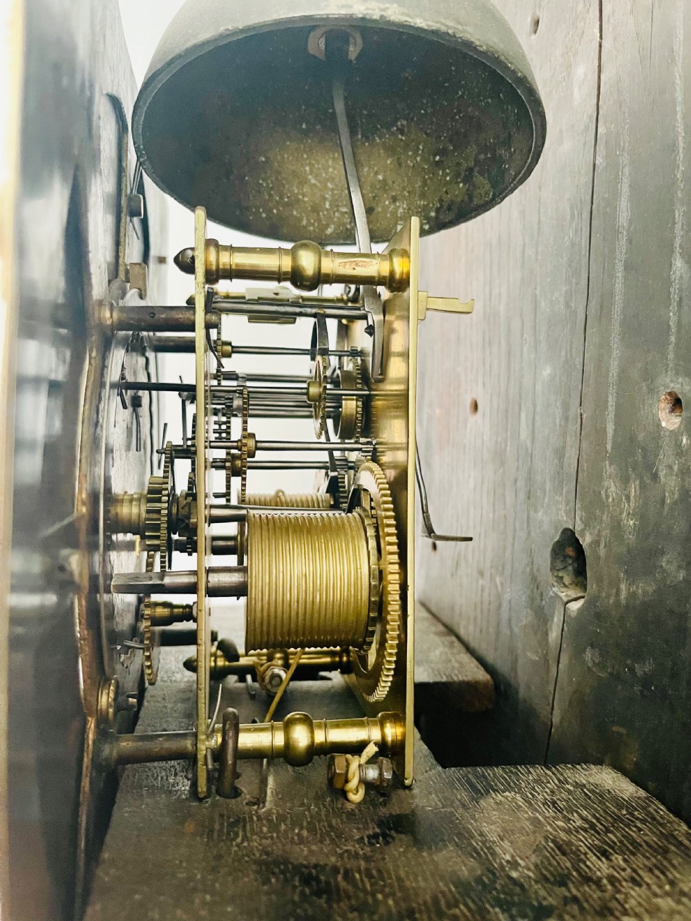 An 18th-century Georgian oak longcase clock featuring a square brass dial with silvered chapter ring, brass spandrels, twin brass finials, and a tall slender timber case. View XXI