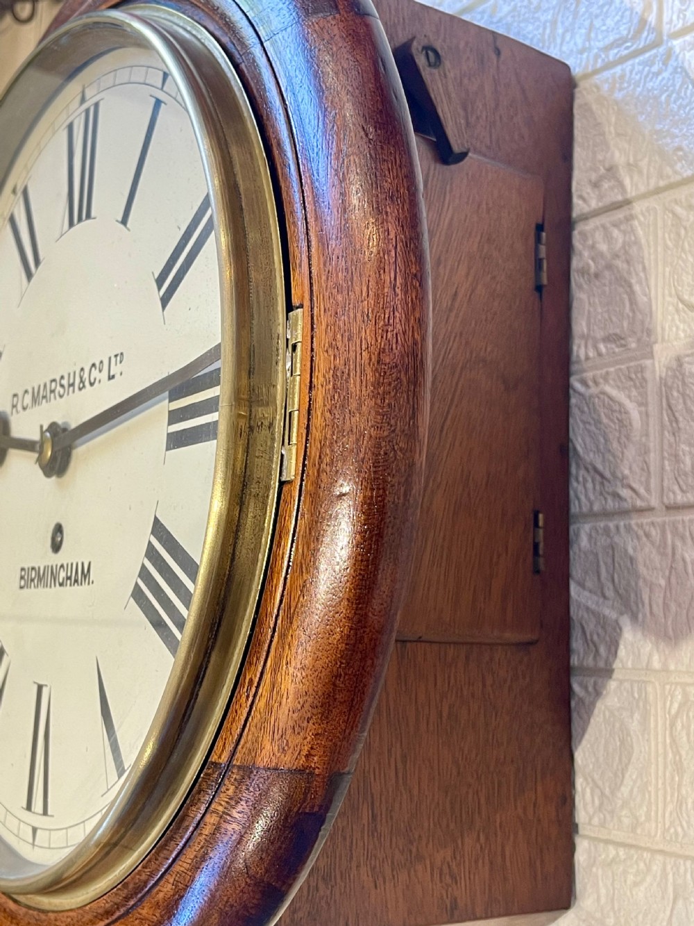 A circular Victorian oak fusee wall clock featuring a white dial with Roman numerals, black hands, and a brass bezel. View X
